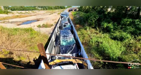 Un train décapités par un pont, plusieurs véhicules neufs complètement détruits.